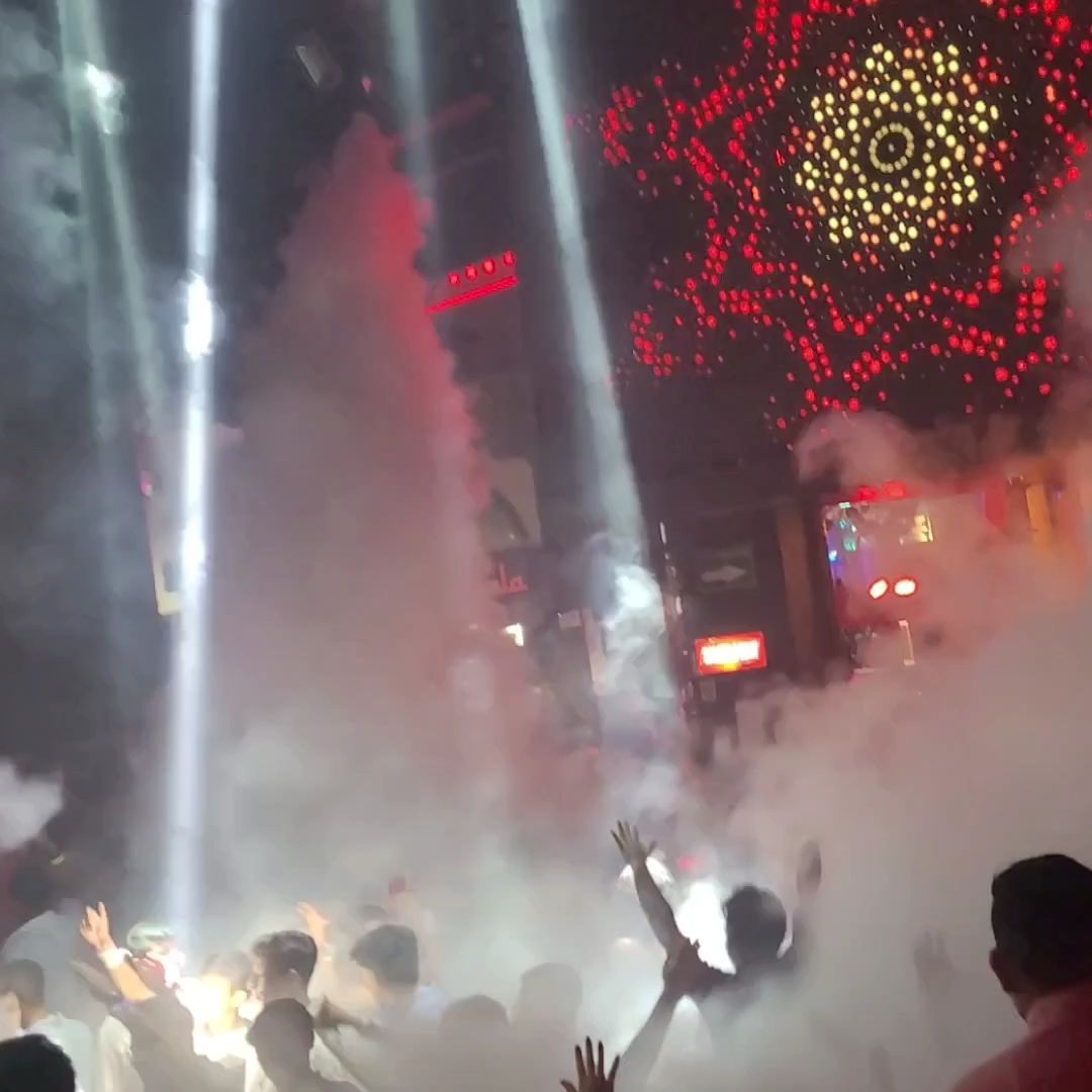 Crowd dancing in a Cancun nightclub with neon lights, smoke effects, and high energy.