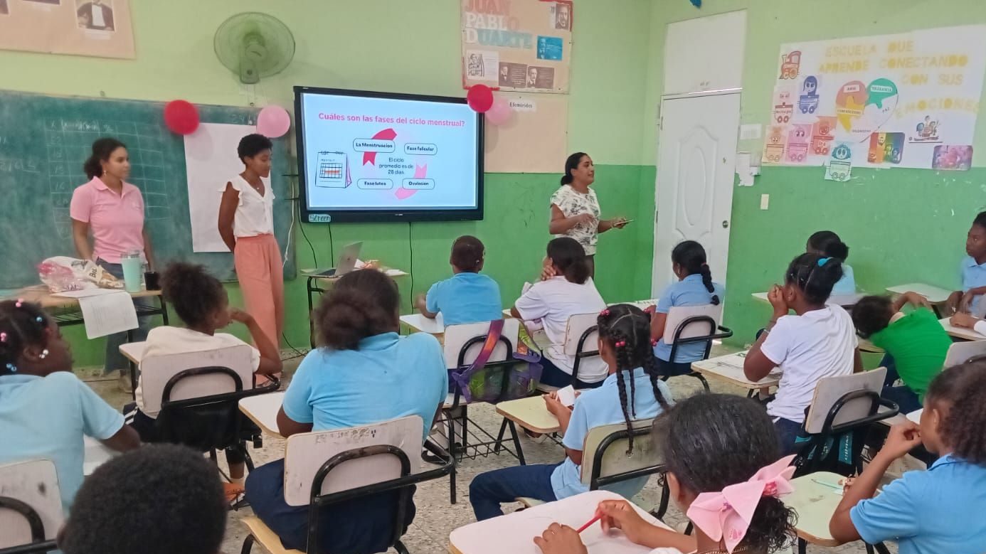 Two Peace Corps Volunteers and school psychologist presenting on menstrual health in a Dominican school.