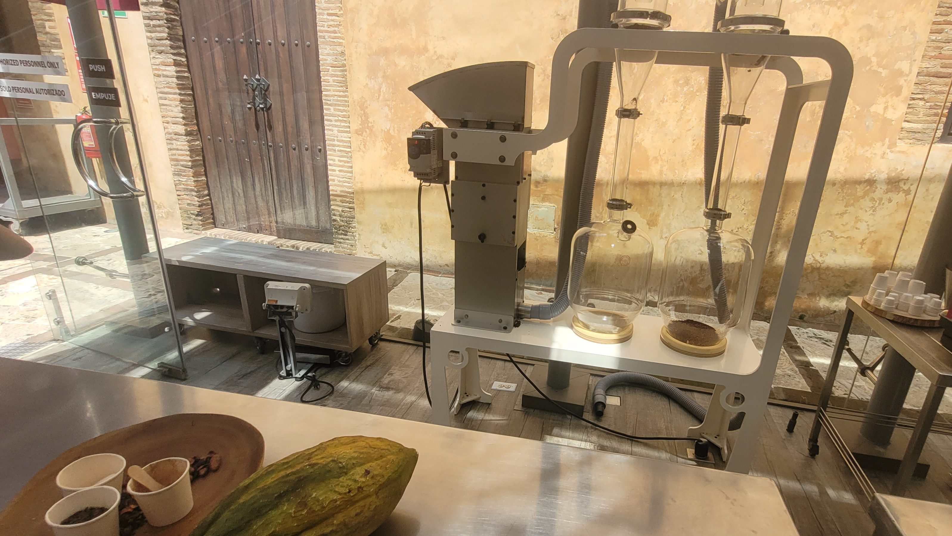 A cacao processing machine and tools set up inside the Museo de Cacao in the Zona Colonial, Santo Domingo, showcasing equipment for chocolate production.